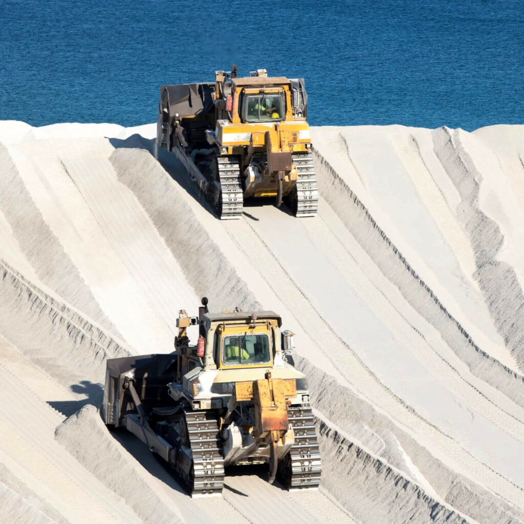 two bulldozers on a pozzolan pile